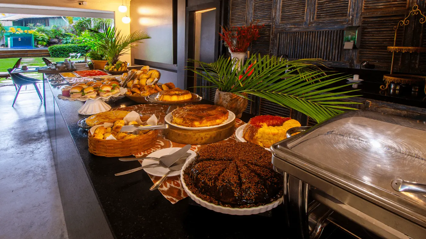 Mesa do café da manhã com bolos e tortas, servido até as 10h30
