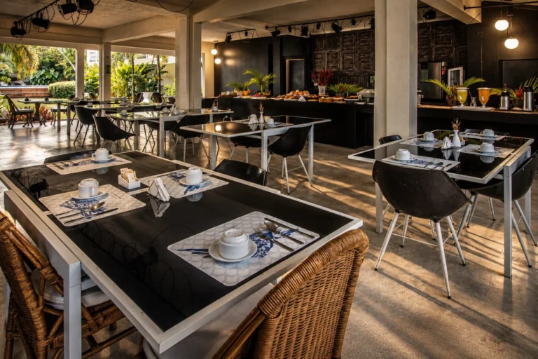 Salón del desayuno con las mesas puestas y el buffet al fondo