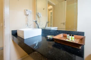 Banheiro do Familiar Conjugado, com bancada de granito e amenities