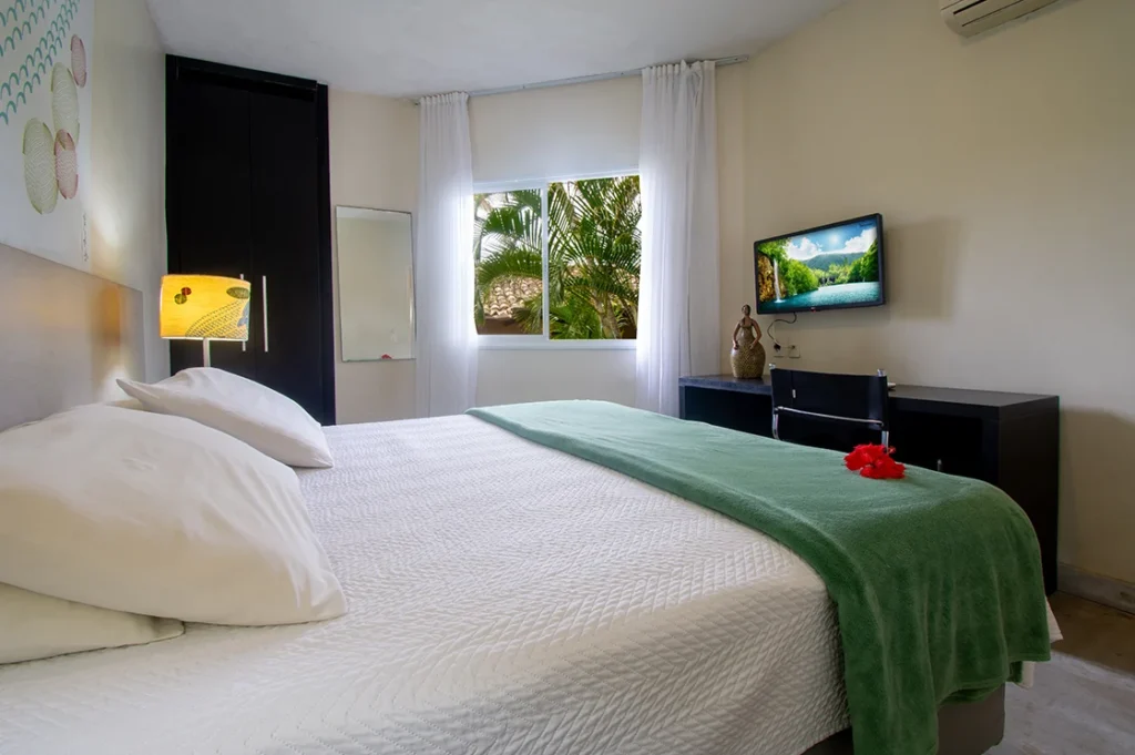 Quarto de casal do Familiar Conjugado, com cama de casal e janela para o verde