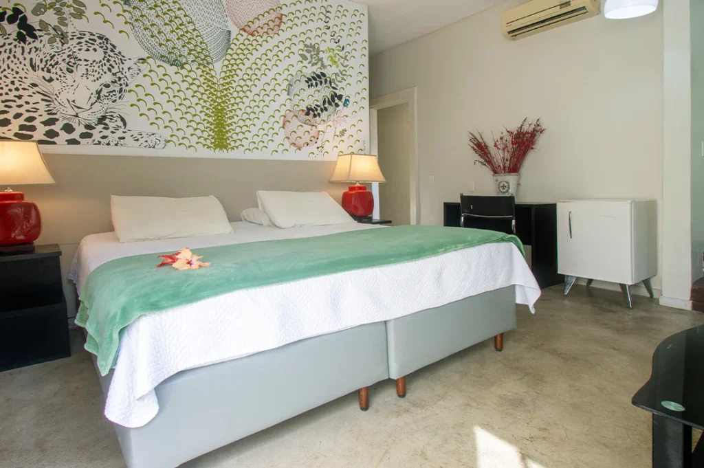Cama queen da Suíte Luxo preparada com decoração romântica
