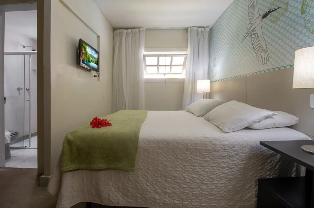 Suíte Standard com cama de casal, TV e janela alta