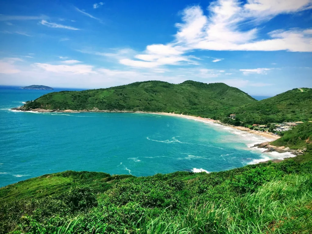 Praia de areia clara entre morros verdes em Búzios, vista do alto