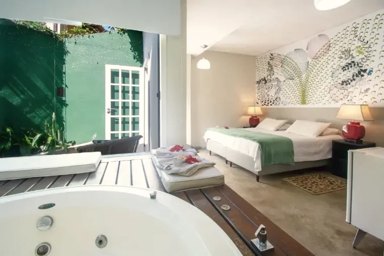 Suíte Luxo: banheira de hidromassagem, cama e porta para o jardim